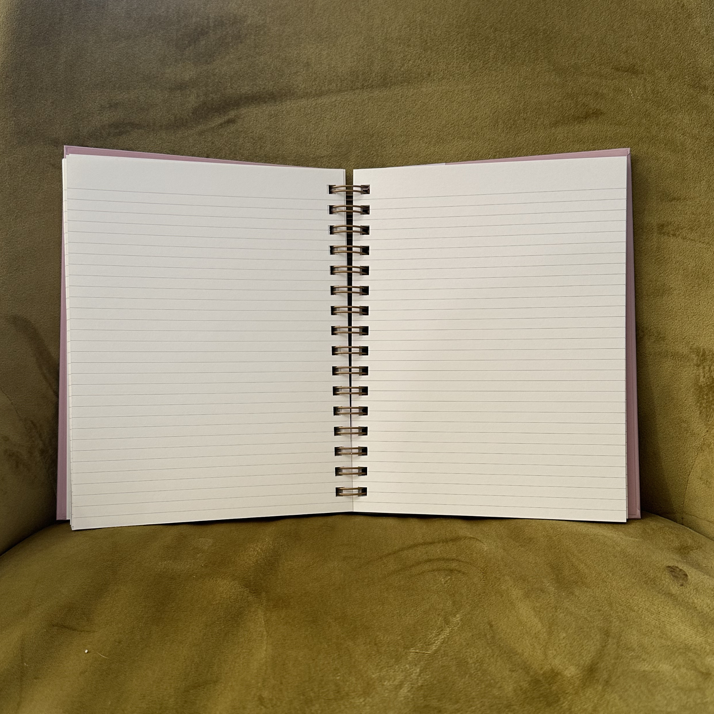 Open notebook with lined pages on a textured green surface