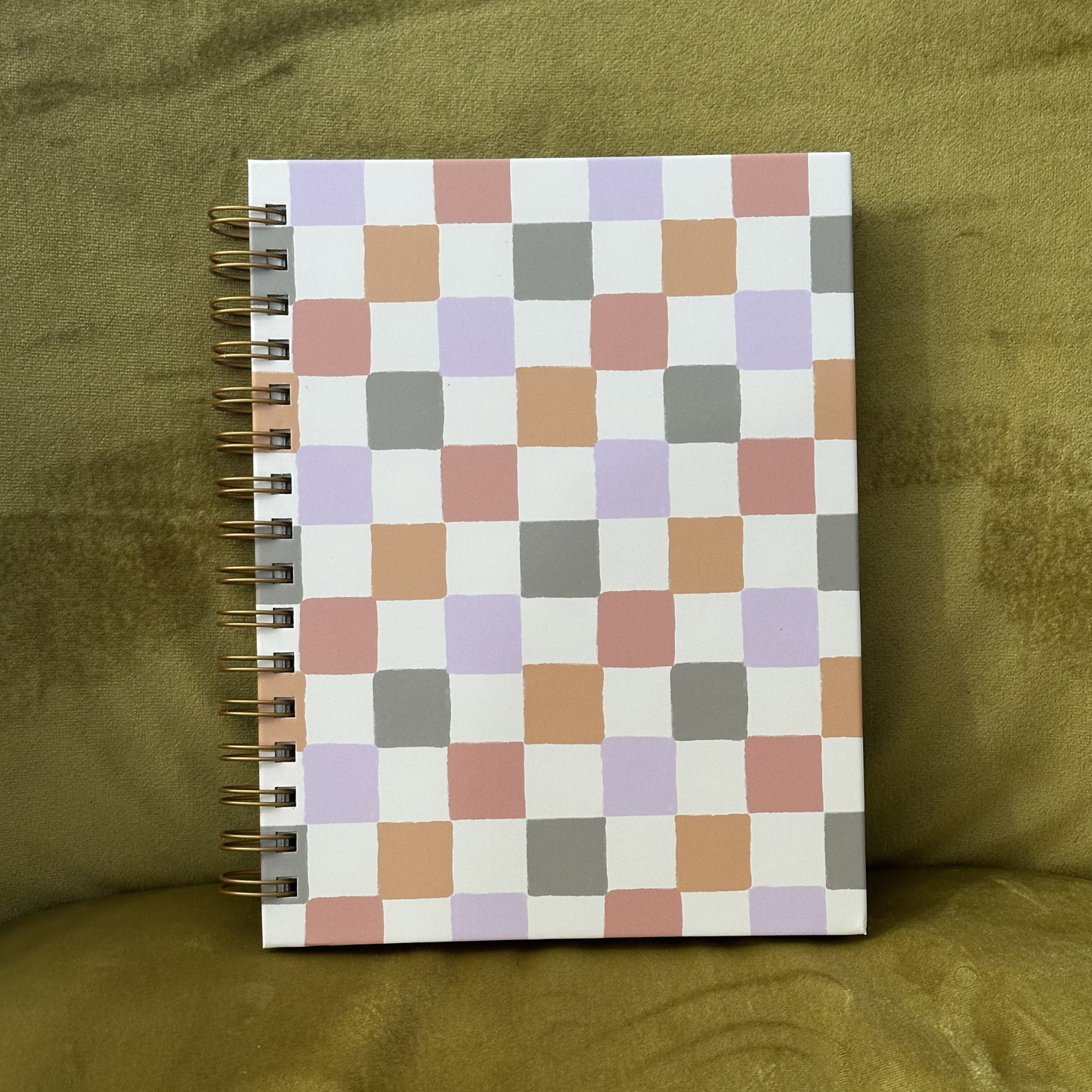Notebook with a checkered cover on a green fabric background